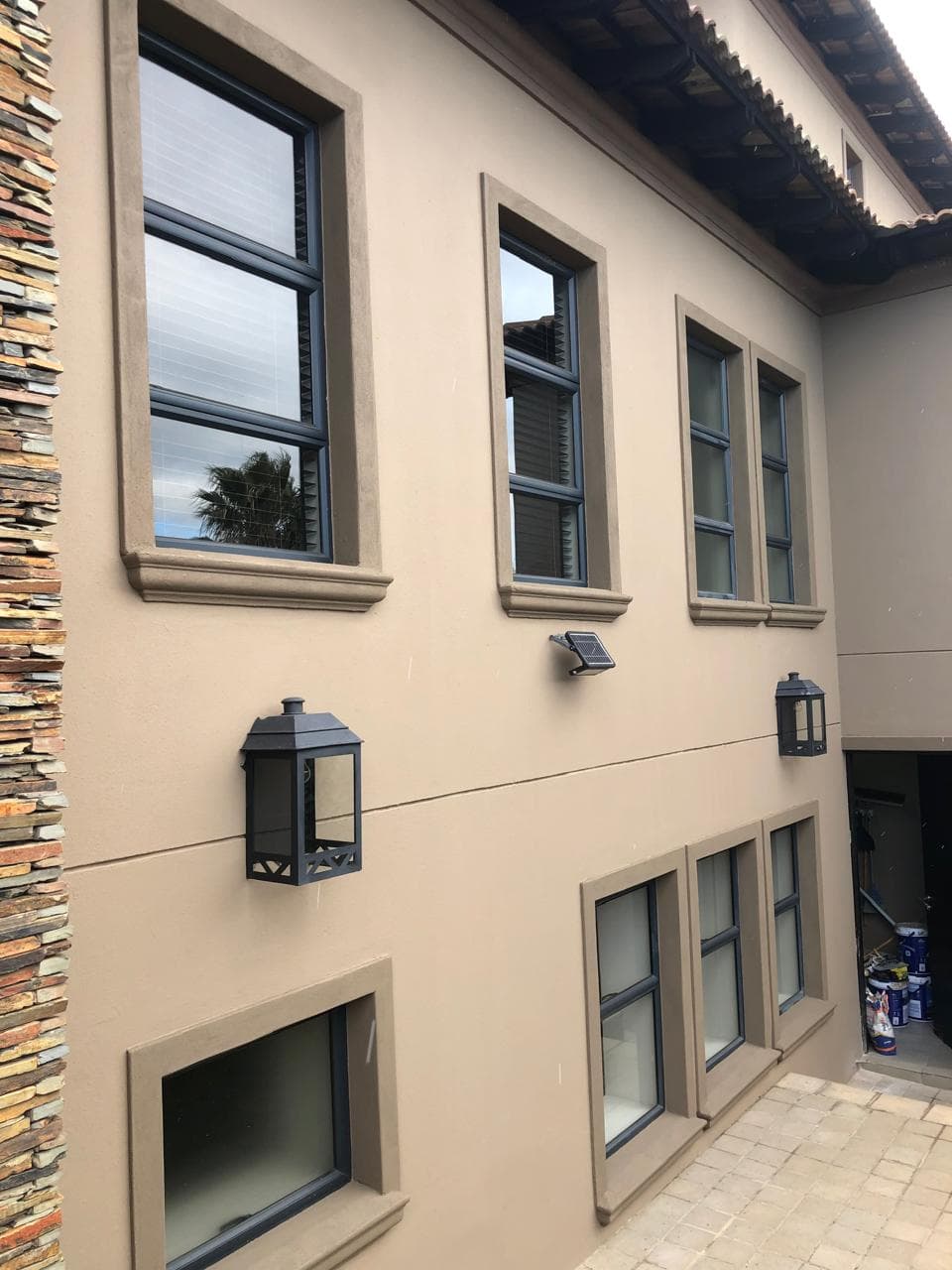Finished taupe exterior wall with dark window frames