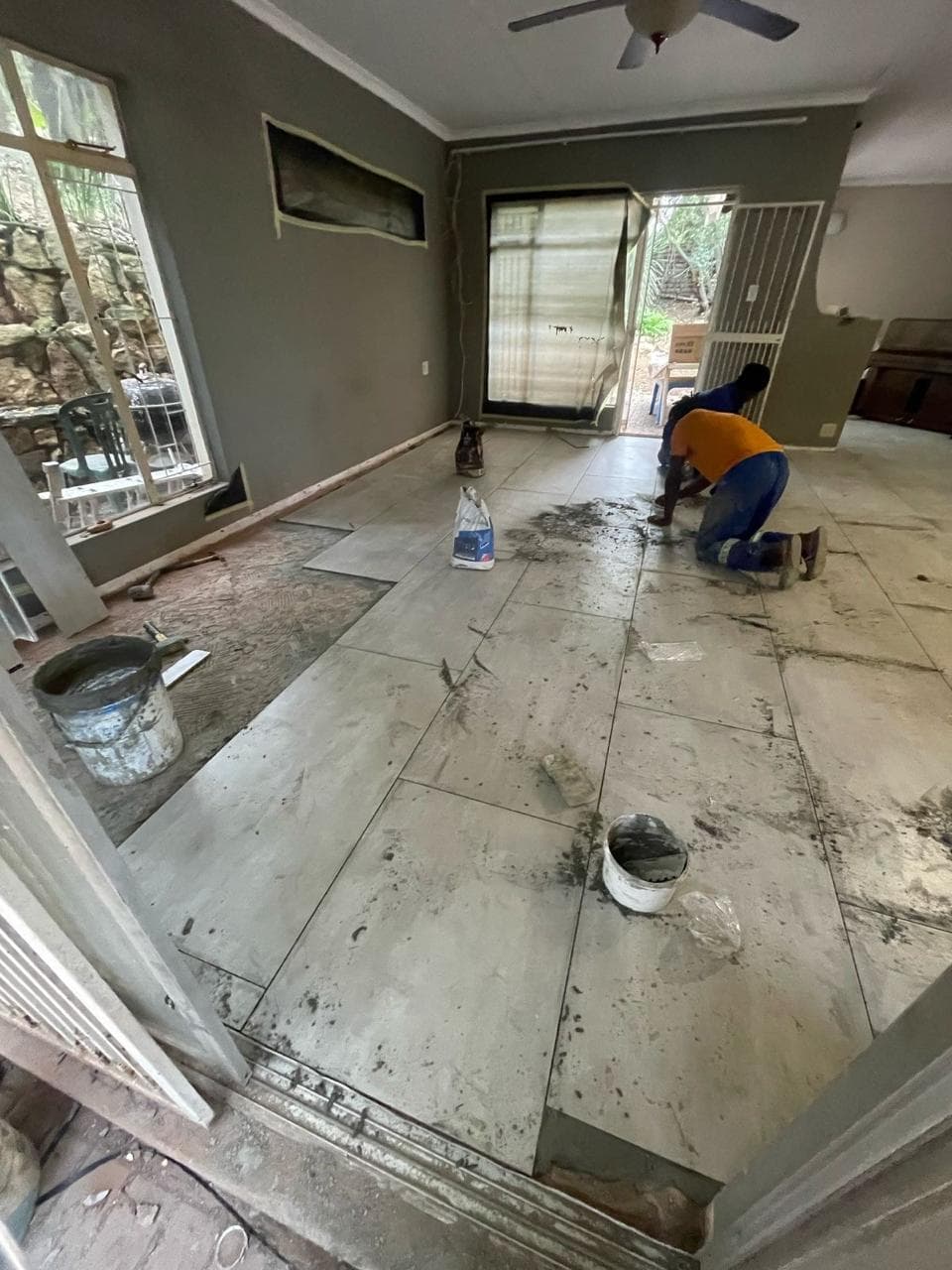 Large-format floor tiles being laid in a Johannesburg home