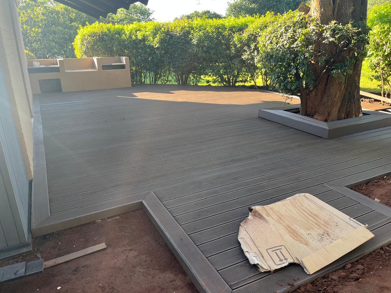 Composite deck with a picture-frame border around a tree